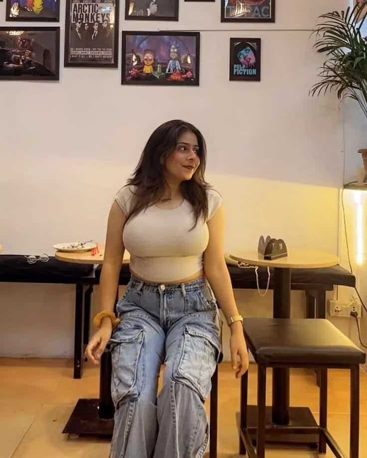 Stylish escort posing on hotel bed for overnight companionship